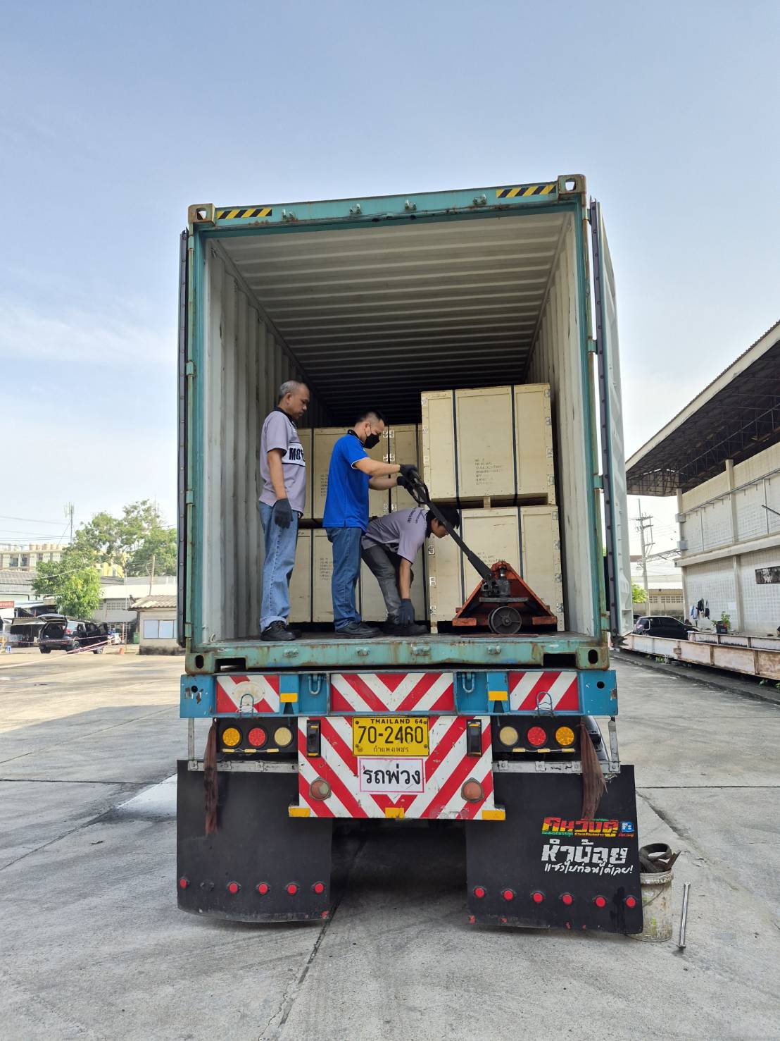MPC team unloading crated chain shipment from container truck using pallet jack